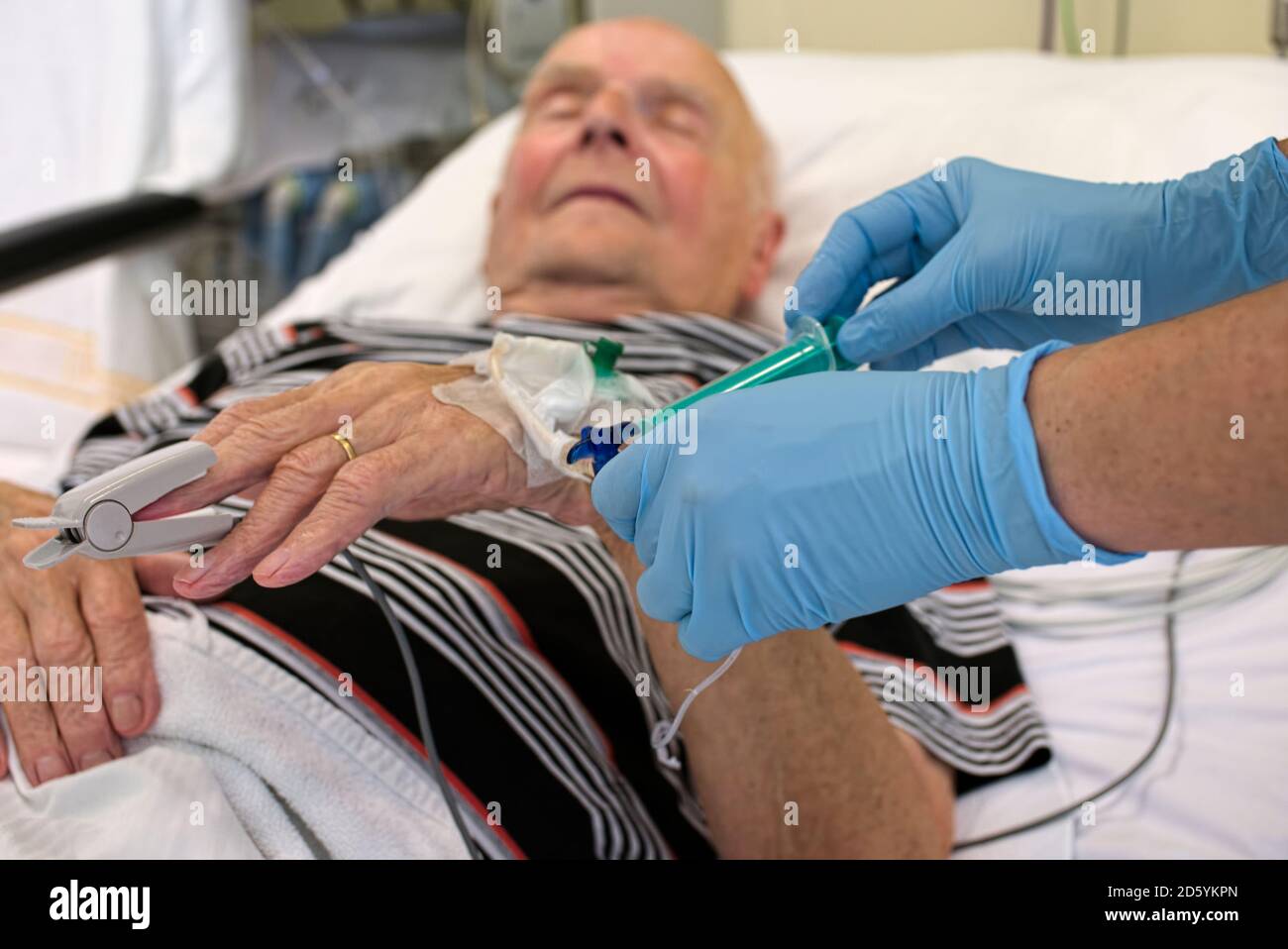 Prélèvement d'un échantillon de sang de l'homme principal étant en soins intensifs après une crise cardiaque Banque D'Images Prélèvement d'un échantillon de sang de l'homme principal étant en soins intensifs après une crise cardiaque Banque D'Images