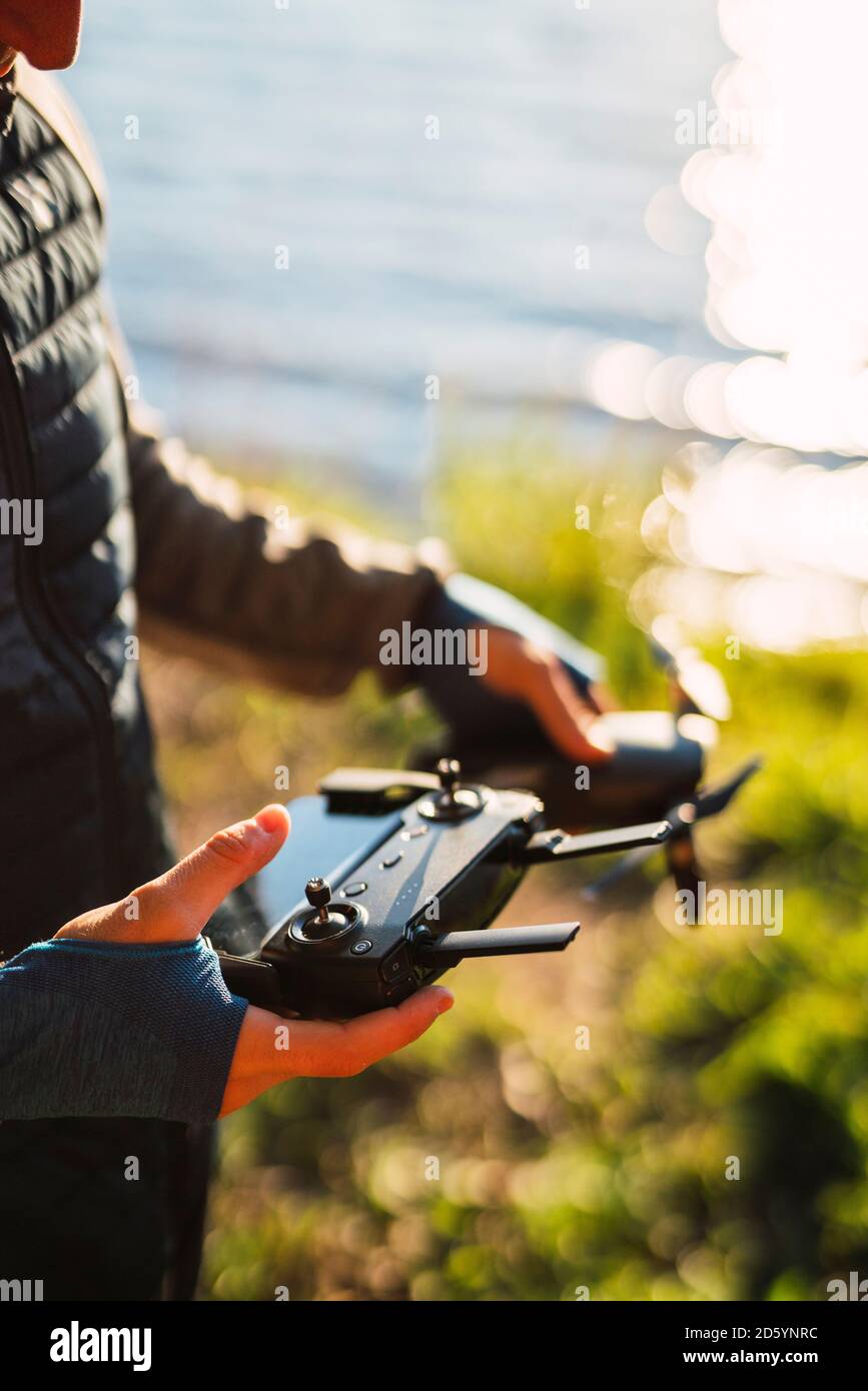 Homme tenant un drone et un télétéléphonique à un lac Banque D'Images