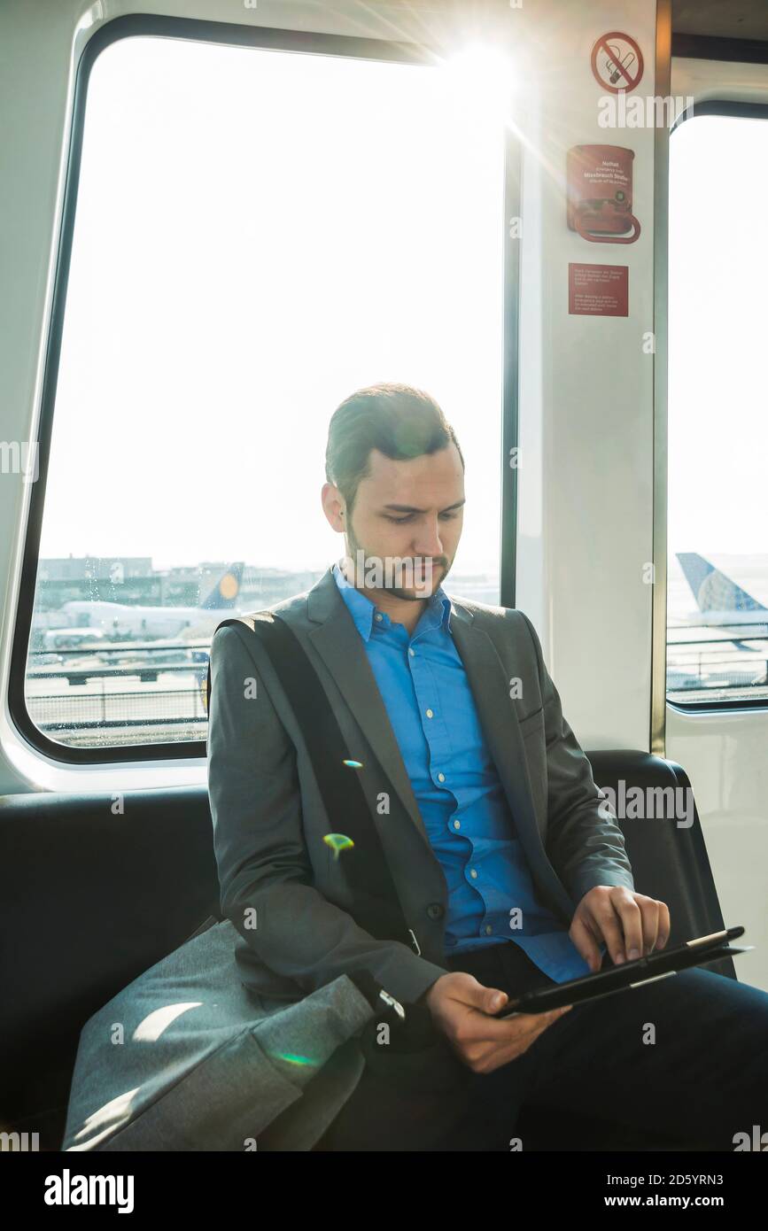 Allemagne, Francfort, jeune homme d'affaires en bus à l'aéroport Banque D'Images
