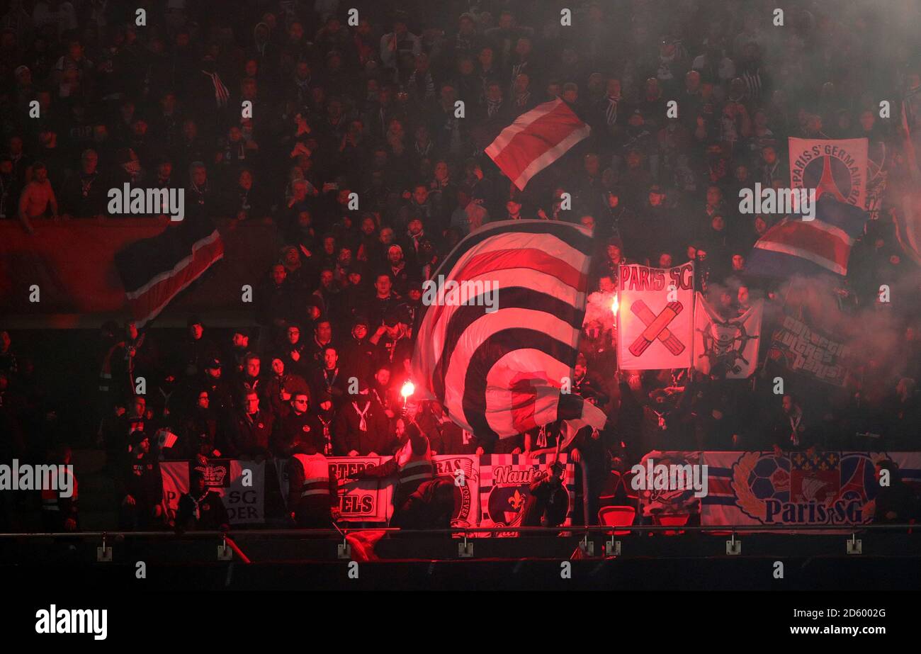 Les fans de Paris Saint-Germain dans les tribunes brandissent des drapeaux, des bannières et des fusées éclairantes pour montrer leur soutien pendant le match Banque D'Images