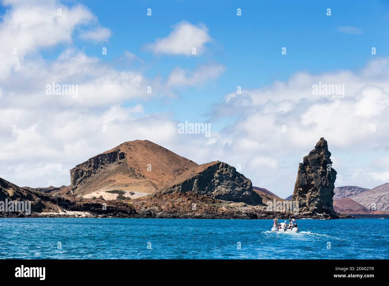L'Équateur, Îles Galápagos, Bartolome, touristes roulant en bateau gonflable en face de Pinnacle Rock Banque D'Images