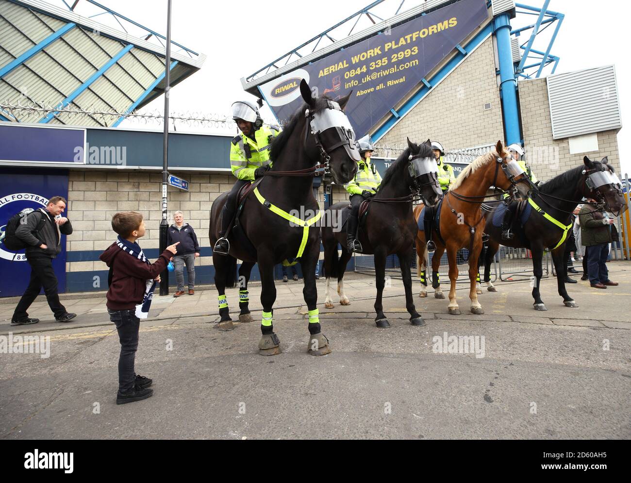 Un jeune fan avec des chevaux de police avant le match de football de Millwall et du championnat Sky Bet de Bristol City, au Den dans le sud de Londres Banque D'Images