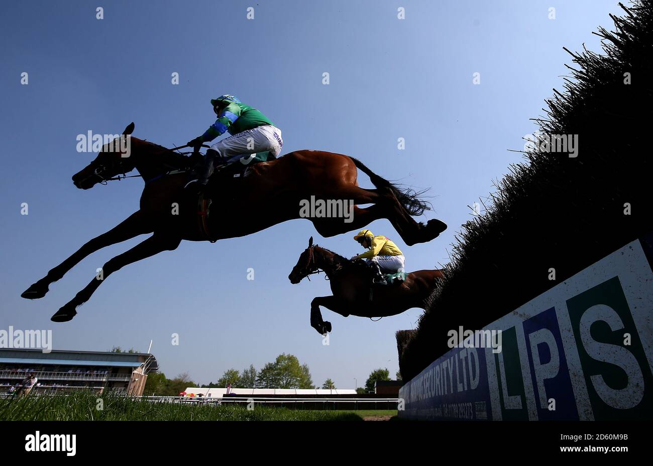 Gun Shy monté par le jockey Jamie Moore et sous le téléphone monté par Jockey Charlie poste (à droite) pendant le Qatar Airways Handicap Chase pendant la Journée des enfants Carnival de Qatar Airways Mai Carnival Racing à Warwick Racecourse. Banque D'Images