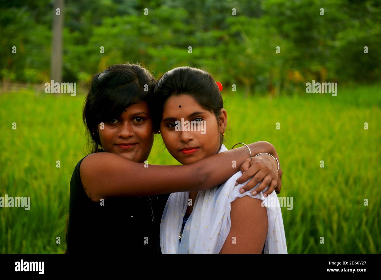 Près de deux adolescentes portant des robes indiennes colorées de salwar kameez dans un champ de paddy vert du Bengale occidental, concentration sélective Banque D'Images