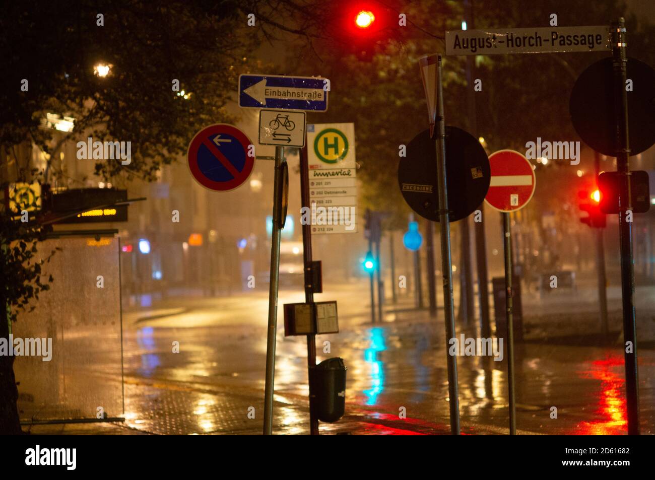 Nuit de pluie dans la grande ville, voitures en voiture dans la rue. Image défocuée. Feux de signalisation et de nombreux panneaux de signalisation au premier plan. Banque D'Images