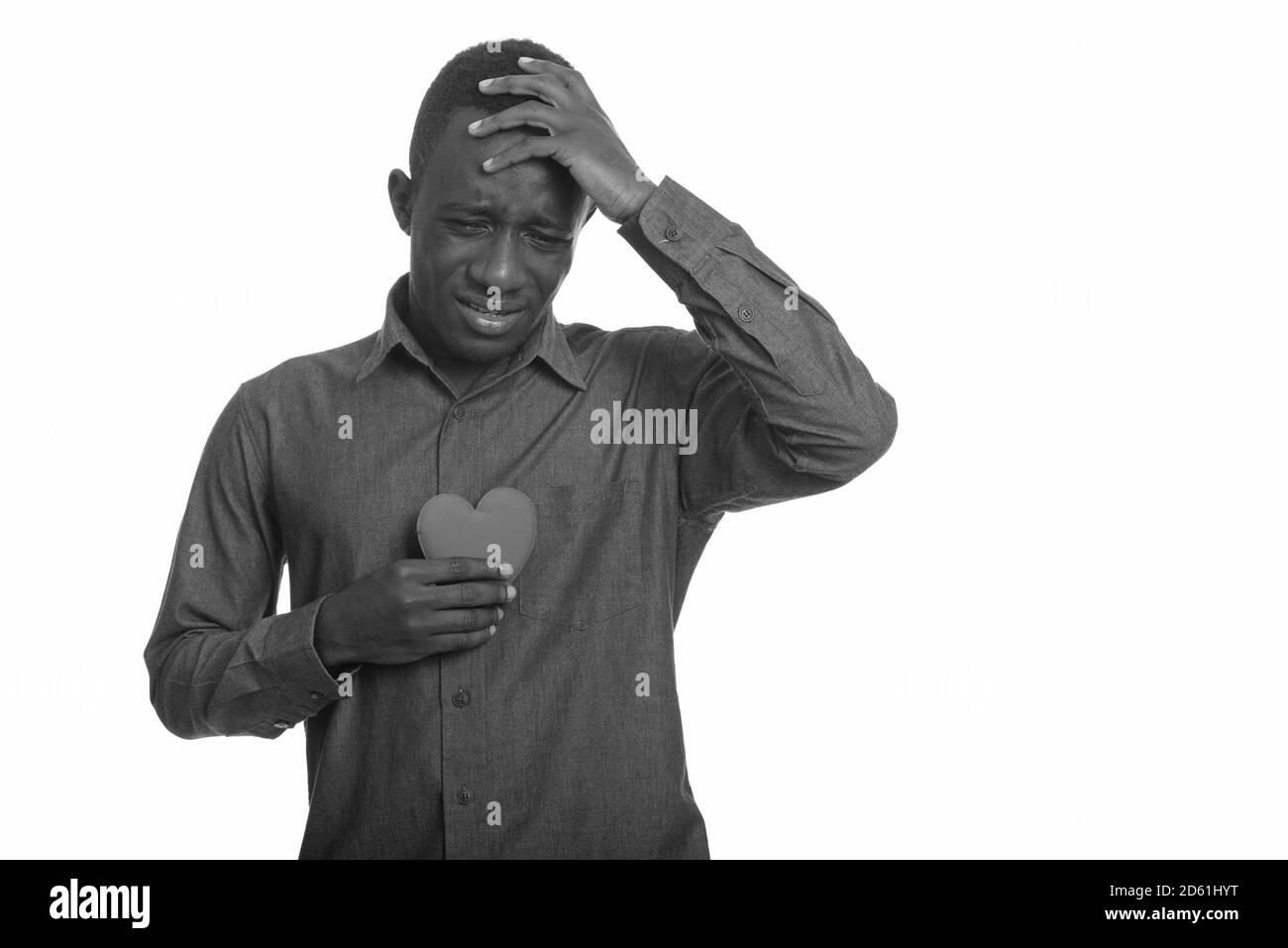 Triste homme africain pleurant tout en tenant le coeur sur la poitrine Banque D'Images