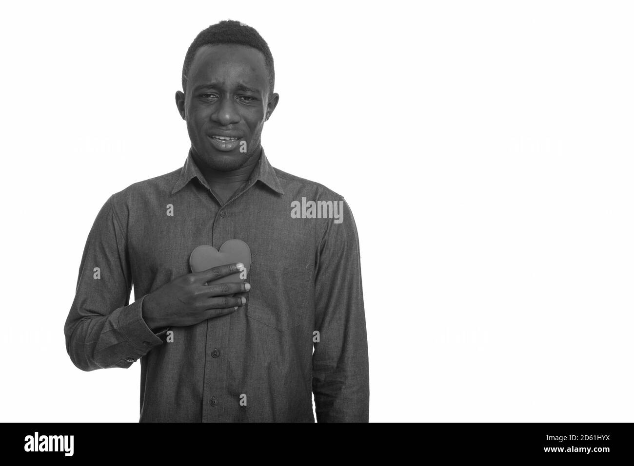 Jeune homme africain triste tenant le coeur sur la poitrine Banque D'Images