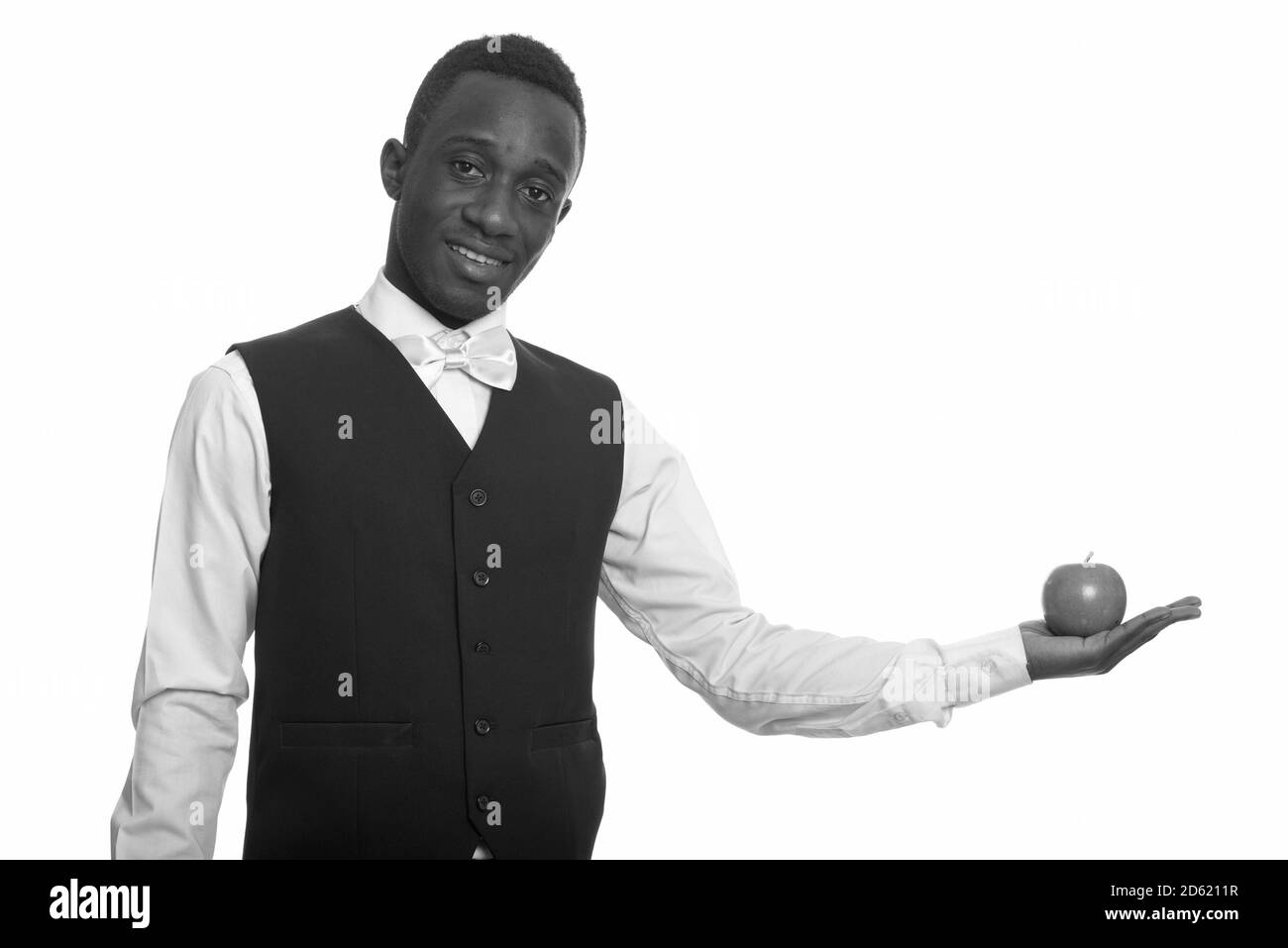 Jeune serveur africain heureux souriant et tenant la pomme Banque D'Images