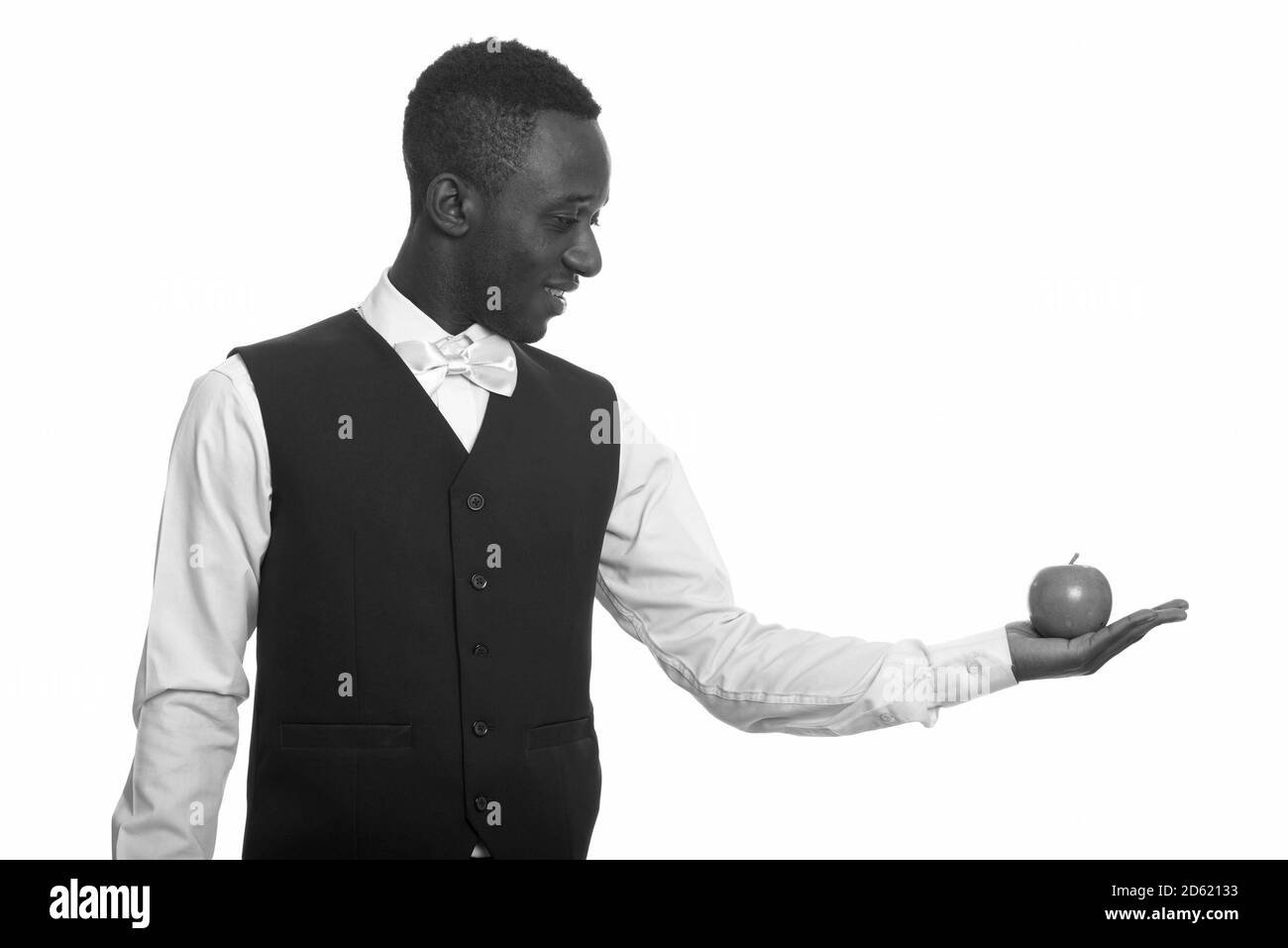 Jeune serveur africain heureux souriant et tenant la pomme Banque D'Images