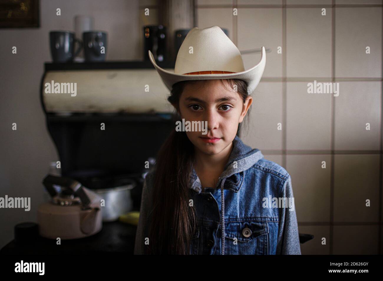 Portrait de la jeune fille Cristina Burboa, âgée de 10 ans, qui porte un chapeau de cow-boy dans la cuisine de sa grand-mère Domitila Burbua le 9 octobre 2020 dans la ville de Fronteras, au Mexique. Fronteras, Sonora. Cowgirl, visage, look, jeans dans le son. (Photo par Luis Gutierrez / Norte photo) Retrito de la niña Cristina Burboa de 10 años que viste de sombrero vaquero en la cocina de su abuela Domitila Burbua el 9 octubre 2020 en el pueblo de Fronteras, Mexique. Fronteras, Sonora. Vaquera, rostro, mirada, vaqueros en sonora. (Photo par Luis Gutierrez/Norte photo) Banque D'Images