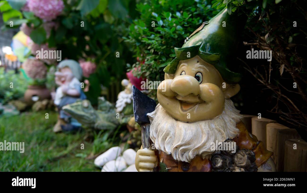 Joyeux jardin gnome avec une hache dans un jardin vert Banque D'Images