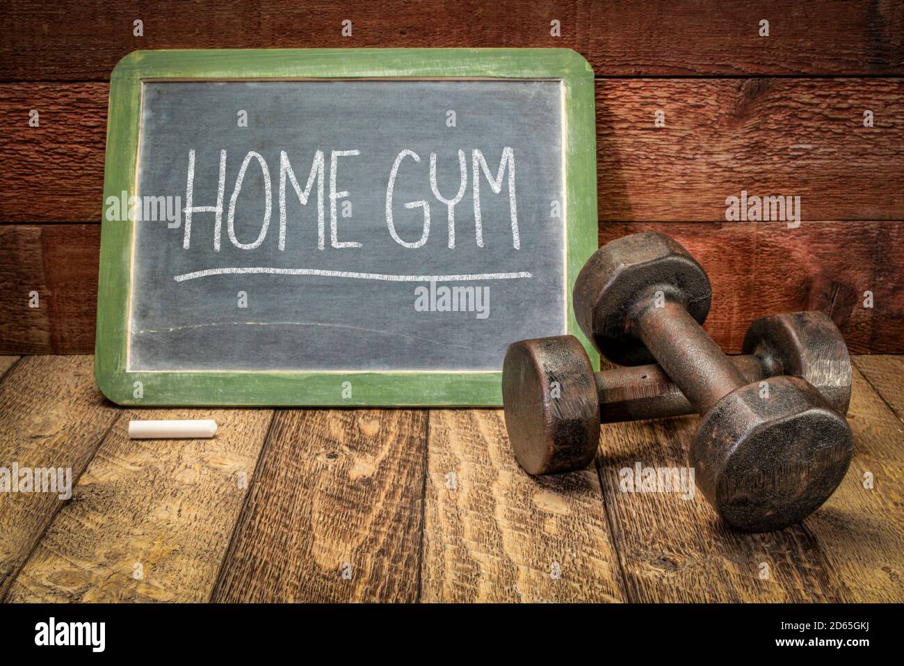 salle de gym à la maison, concept de forme physique et de mode de vie sain, écriture à la craie blanche sur un tableau noir en ardoise avec une paire d'haltères vintage Banque D'Images
