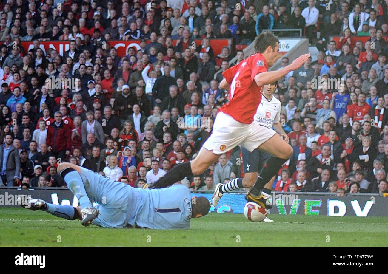 Michael Carrick (à droite) de Manchester United est mis au sol par le gardien de but de Tottenham Hotspur Heurelho Gomes, ce qui entraîne une pénalité. Banque D'Images