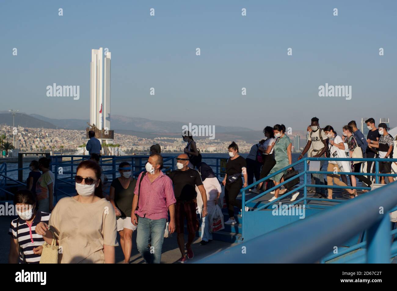 Les passagers portant des masques débarquent d'un ferry à Karsiyaka, Izmir, Turquie Banque D'Images