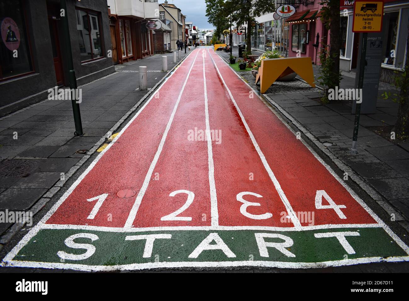 Laugavegur, la principale rue commerçante de Reykjavik, en Islande. Une piste de course rouge numérotée est peinte sur la rue. Le début est écrit dans une zone verte Banque D'Images