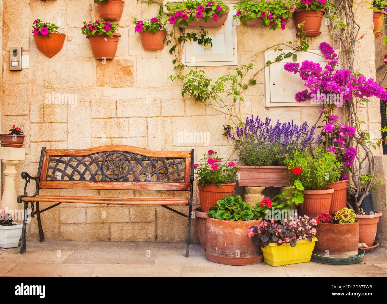 Un banc entouré de nombreux pots de fleurs dans la vieille ville de Monopoli, Puglia, Italie Banque D'Images