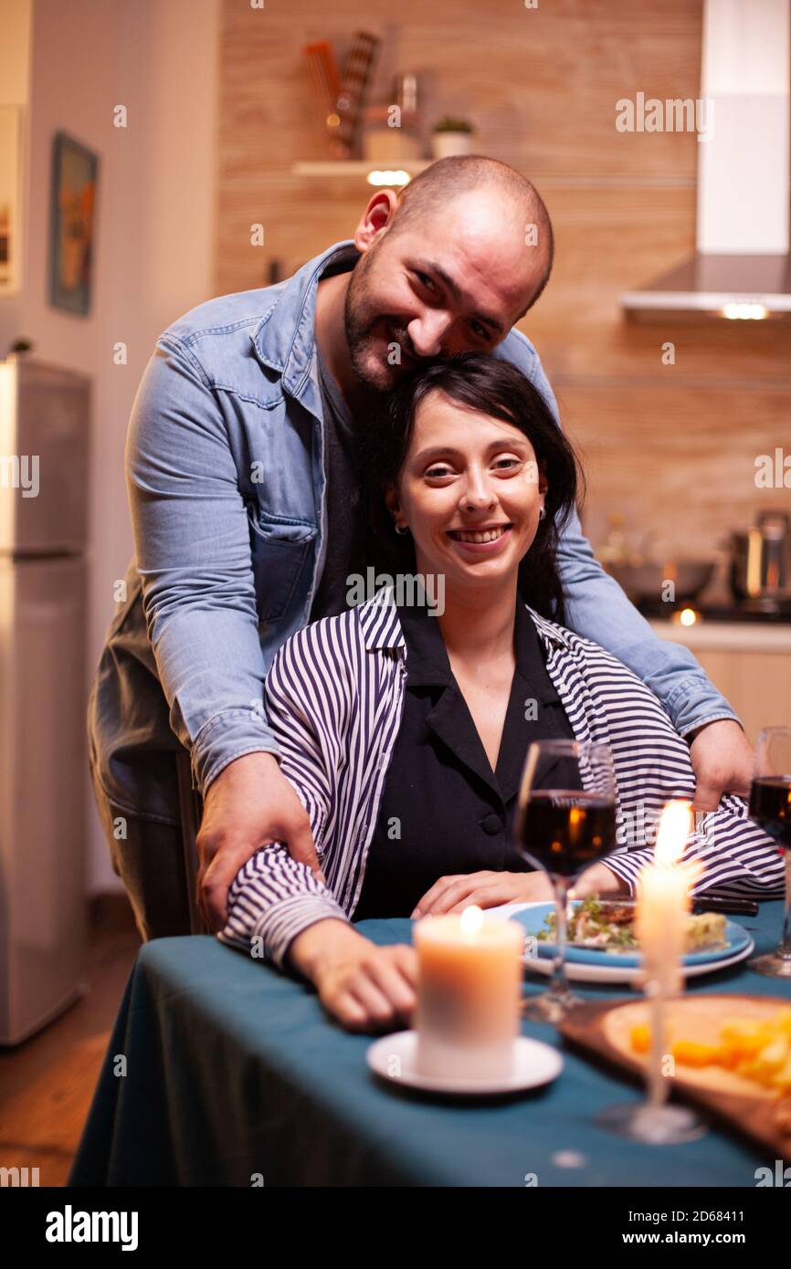 Couple romantique regardant la webcam pendant le dîner romantique. Les personnes mariées ont des moments d'appel d'offres spéciaux, en appréciant le repas à la fête des bougies. Banque D'Images
