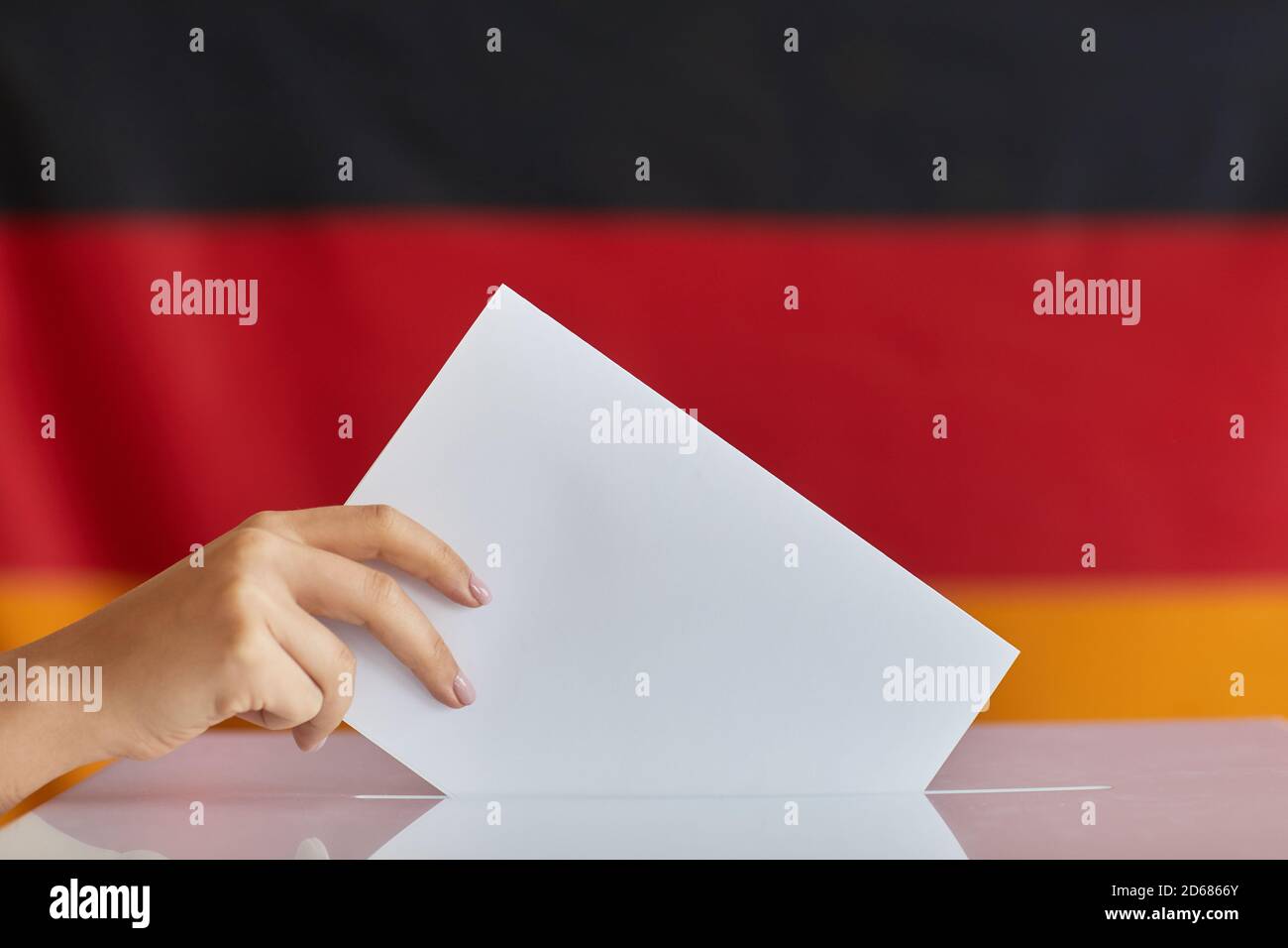 Gros plan de la main féminine tenant une enveloppe blanche et votant bureau de vote Banque D'Images