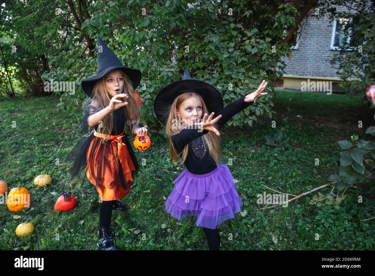 Les petits enfants trick ou de traiter. Deux petits sorcières font peur au voisin pour Halloween Banque D'Images