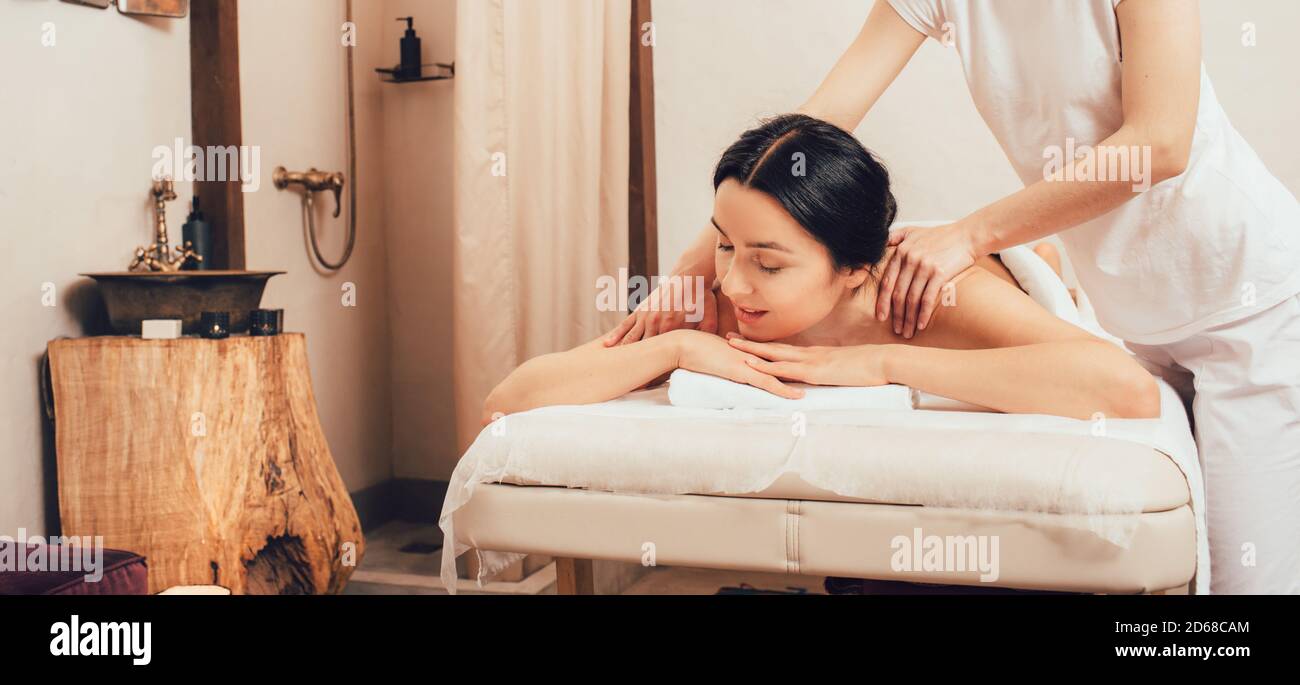 Massage relaxant du dos et du corps au spa. Femme de race mixte profitant d'un massage au spa Banque D'Images