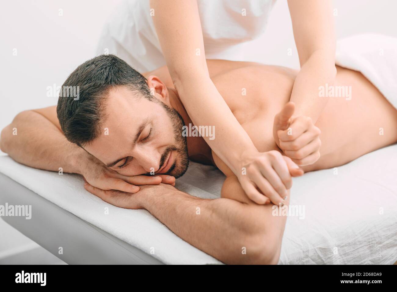 Beau homme arabe qui profite d'un massage du dos au spa. Massage relaxant au spa Banque D'Images