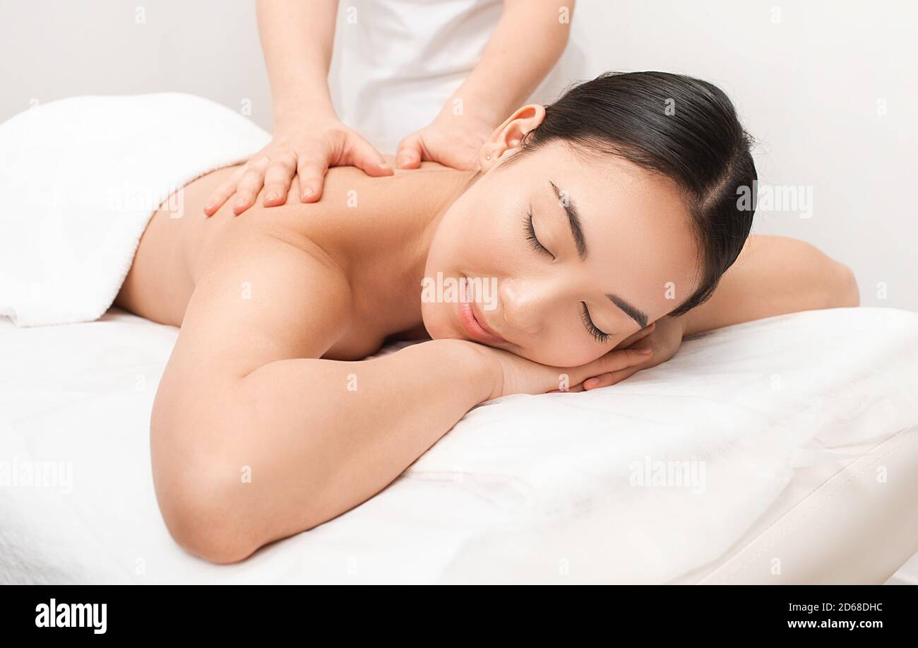 Massage thaïlandais anti-stress. Une belle femme asiatique se fait masser le dos dans un spa thaïlandais Banque D'Images