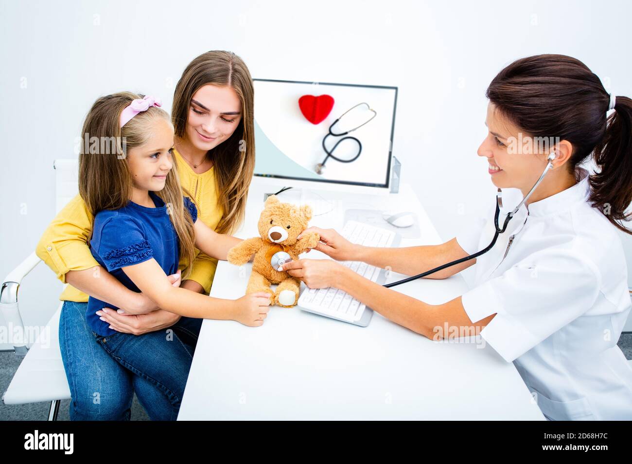 Pédiatre tenir un stéthoscope, communiquer avec une jeune fille patient consulter le médecin avec la mère. Vérifier les poumons cardiaques de l'enfant Banque D'Images