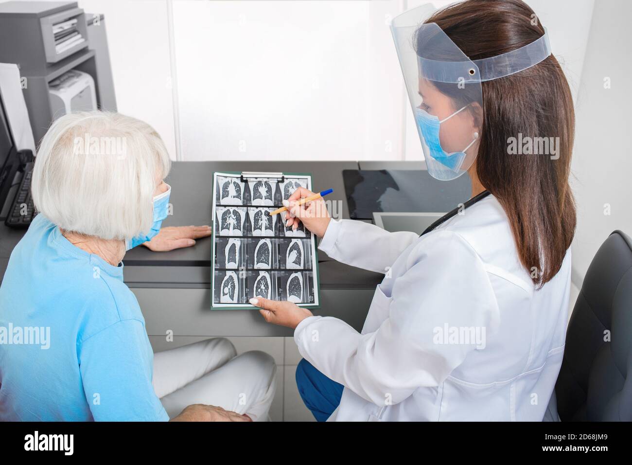Pulmonologieist montrant une patiente âgée une tomodensitométrie de ses poumons. Pneumonie, coronavirus, maladie pulmonaire Banque D'Images