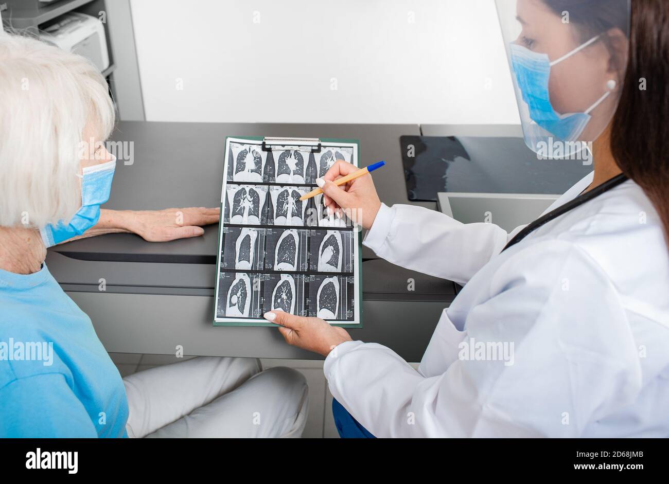 Pulmonologieist montrant à un patient âgé une tomodensitométrie de ses poumons. Pneumonie, coronavirus, maladie pulmonaire Banque D'Images