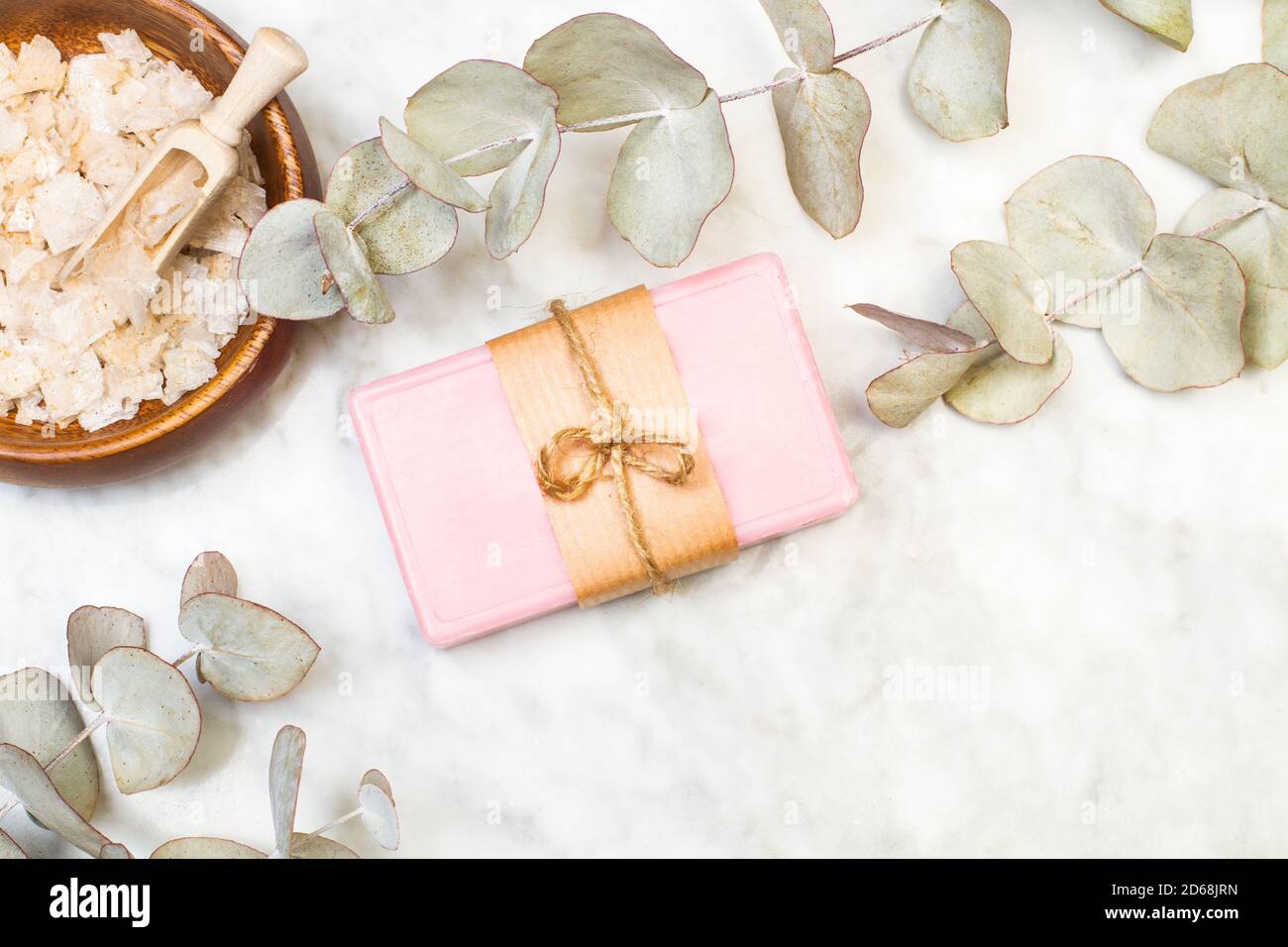 Un porte-savon rose avec des branches d'eucalyptus sur un marbre table dans une vue de dessus Banque D'Images