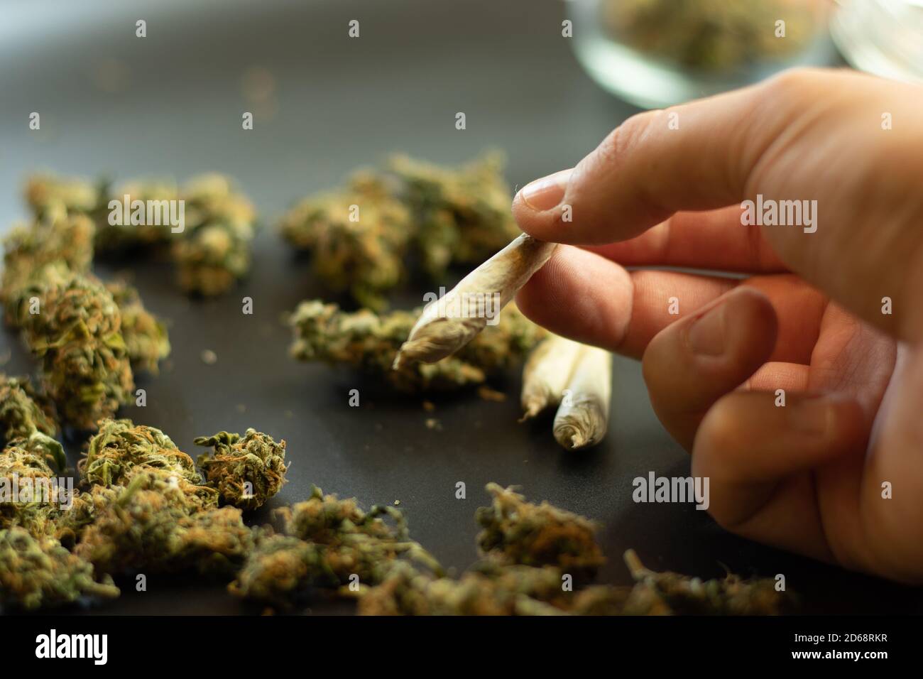 Addiction de drogue concept, homme tenant la marijuana joint dans la main. Copier l'arrière-plan de l'espace avec des bourgeons de cannabis. Programme de tabagisme des mauvaises herbes Banque D'Images