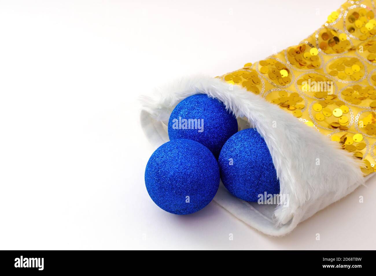 Chaussette de noël jaune en gros plan avec trois boules bleues sur fond blanc. Copier l'espace Banque D'Images