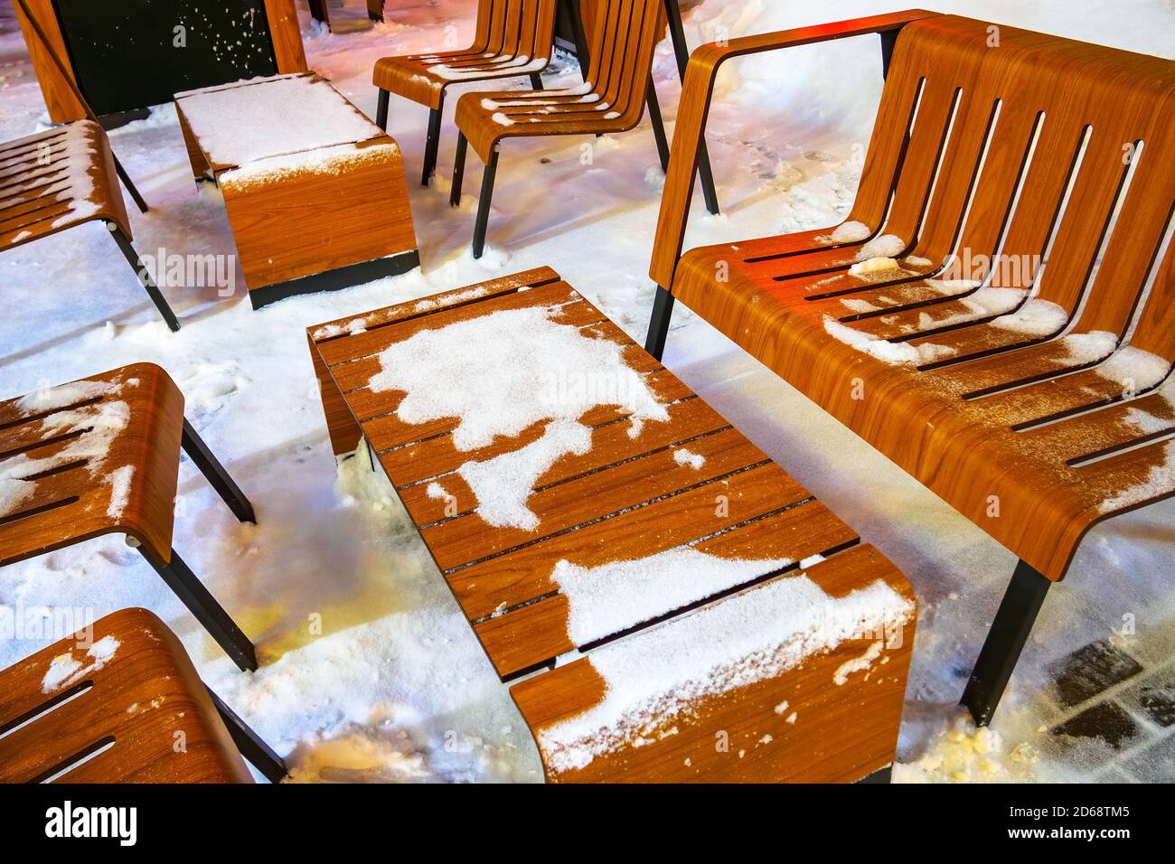 table et chaises en bois marron dans la neige, café de rue sous la lumière d'une lanterne en hiver Banque D'Images