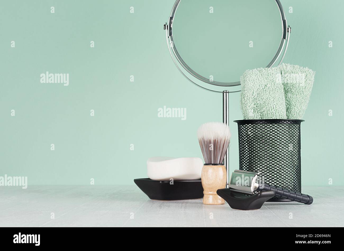 Produits de toilette noirs élégants pour le rasage - rasoir noir, savon, miroir rond, serviette, brosse de rasage sur planche en bois blanc et mur couleur menthe aqua, espace de copie, moi Banque D'Images