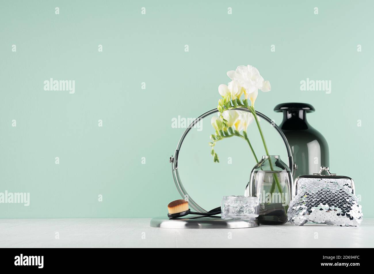 Articles de toilette noirs élégants pour le soin du visage et le maquillage - miroir rond, brosse, fleurs blanches, sac de cosmétiques dans l'intérieur vert aqua menthe, onglet en bois blanc Banque D'Images