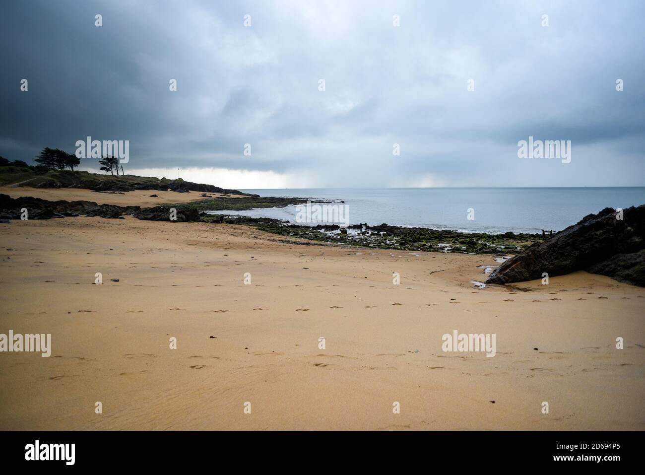 Une plage de sable sur les rives de l'océan pendant le temps orageux. Banque D'Images