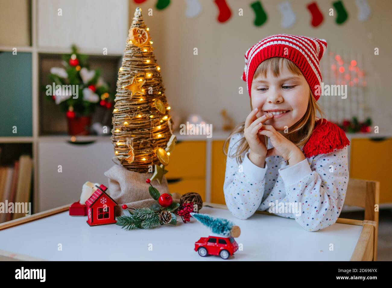 Petite fille de 4 ans dans un chapeau de gnome dans la chambre des enfants. Banque D'Images
