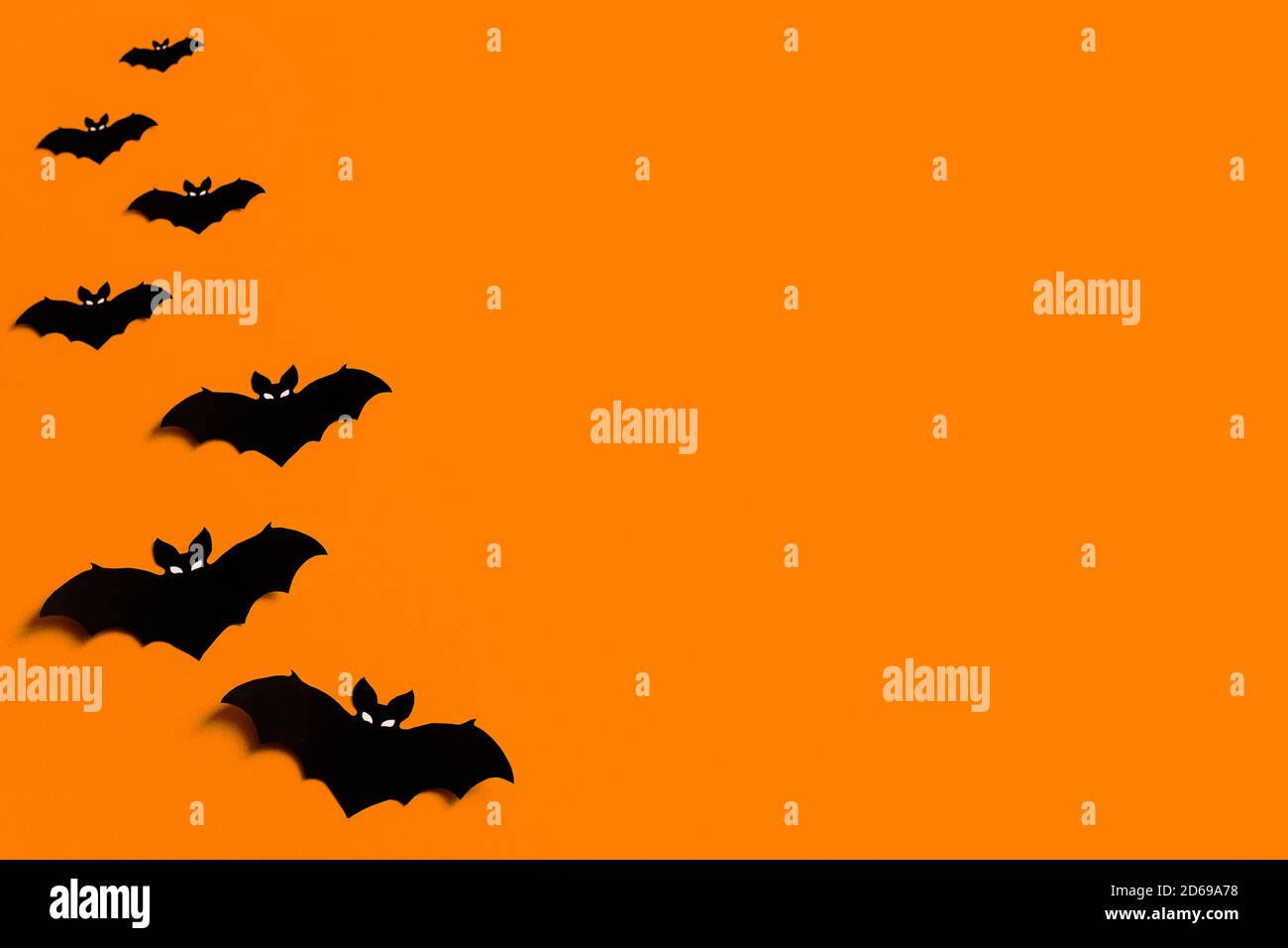 Fond orange avec un troupeau de chauves-souris en papier noir pour Halloween, silhouettes en papier noir sur fond orange, Halloween concept, copyspace Banque D'Images