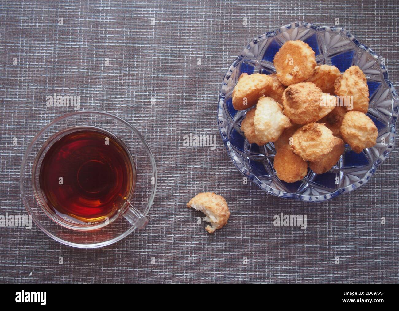 Sur la table, recouverte d'un tissu brun, se trouve une tasse de thé et un bol de biscuits. Encore-vie. Banque D'Images
