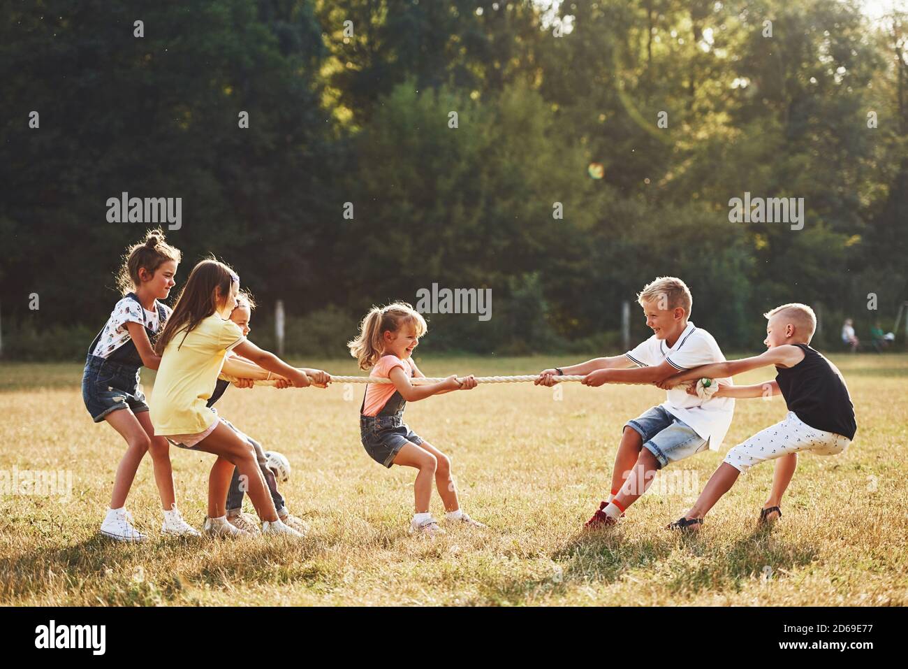 Les enfants qui jouent au jeu de remords de guerre dans la belle prairie par beau temps Banque D'Images