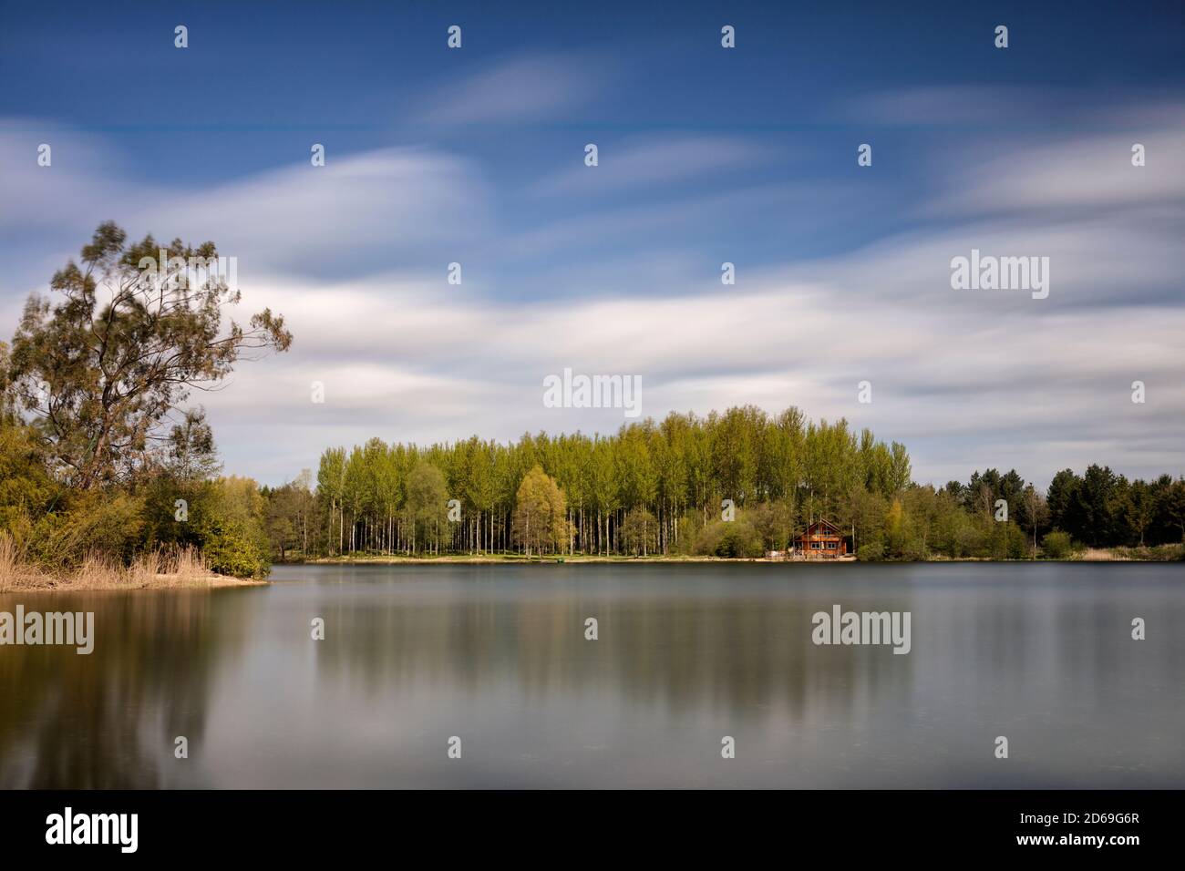 Vue longue exposition sur un lac vers une île avec une forêt de style scandinave de bouleaux et de rondins cabine Banque D'Images