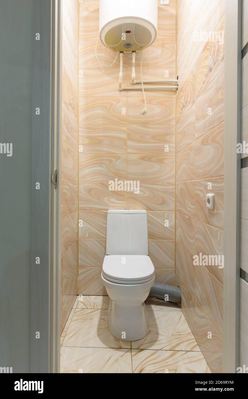 Petite toilette compacte, il y a un chauffe-eau à l'étage Photo Stock -  Alamy