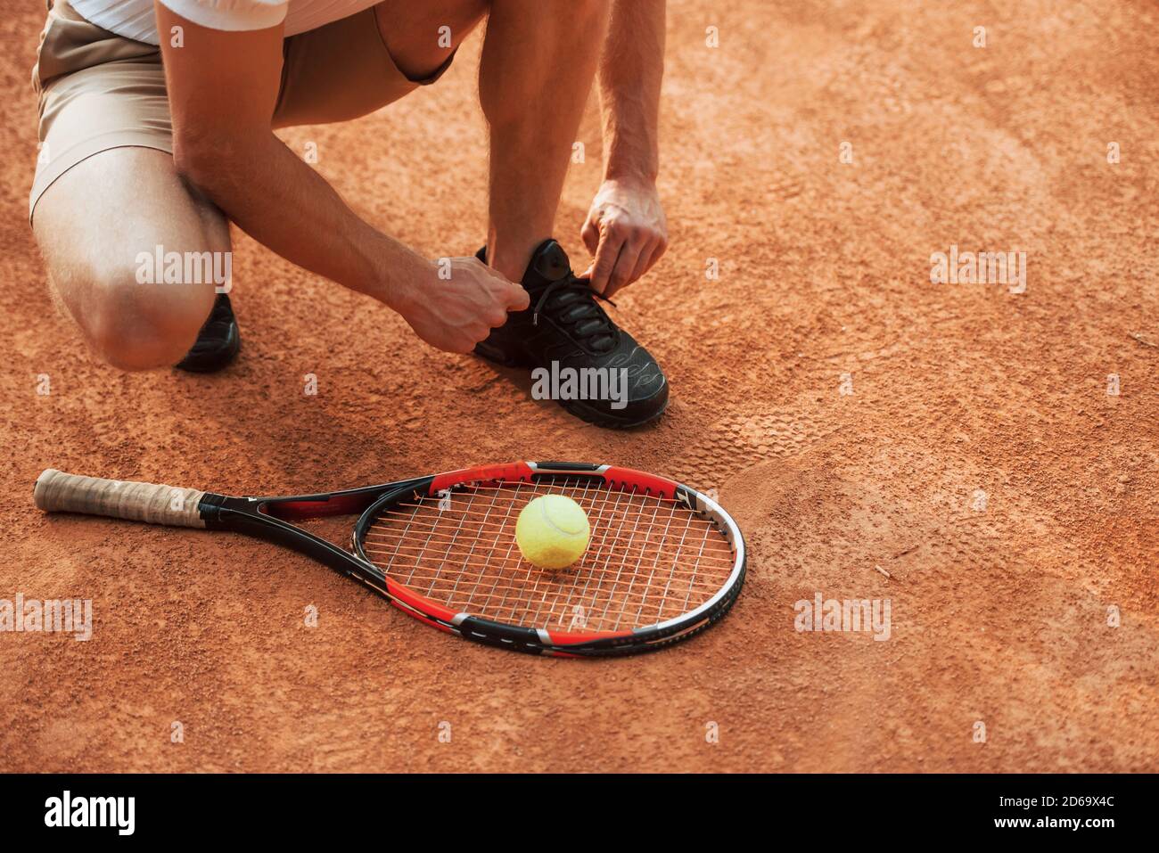 Préparation. Un jeune joueur de tennis en vêtements de sport se trouve sur le court à l'extérieur Banque D'Images