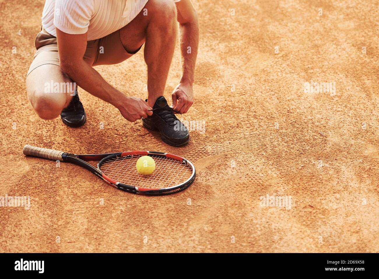 Préparation. Un jeune joueur de tennis en vêtements de sport se trouve sur le court à l'extérieur Banque D'Images