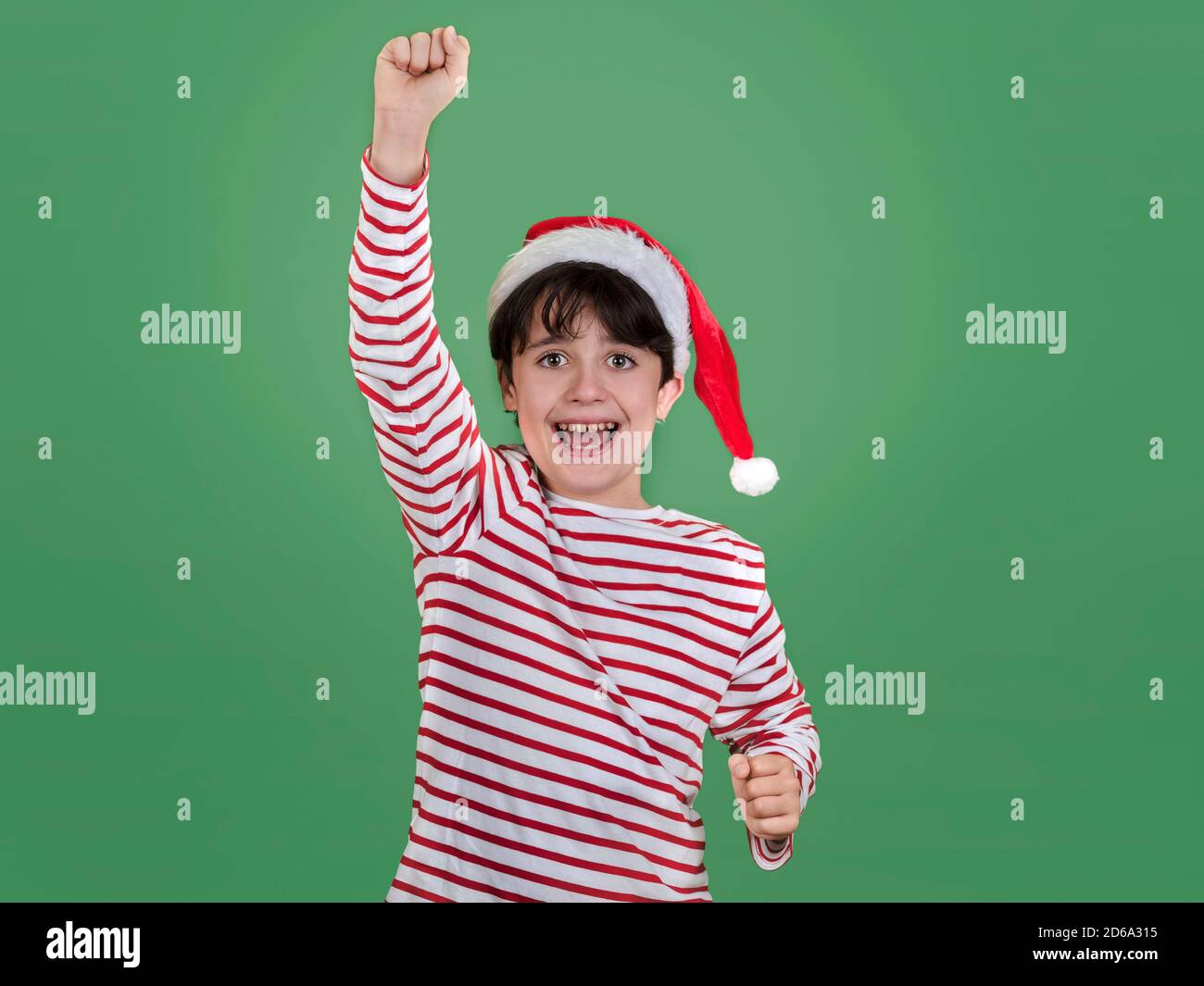 Joyeux Noël, jeune fille souriante portant le chapeau de Noël du Père Noël sur le vert arrière-plan Banque D'Images