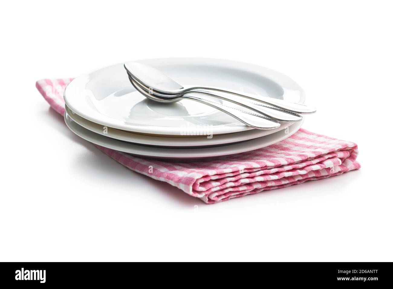 Assiettes et cuillères à dessert sur une serviette à carreaux isolée sur fond blanc. Banque D'Images