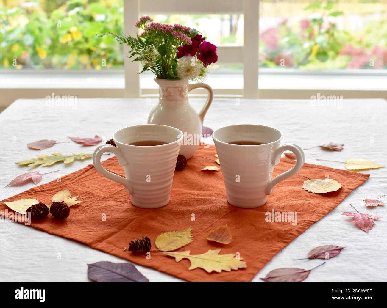 Boisson chaude d'automne aux épices de citrouille pour un repas frais les jours d'automne avec le fond des feuilles tombées éléments décoratifs Banque D'Images