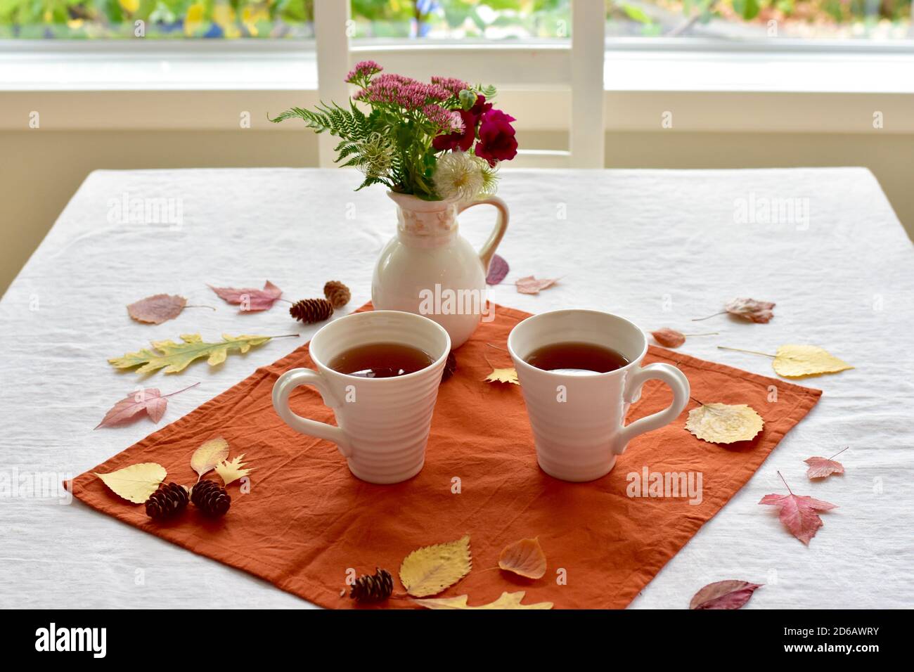 Boisson chaude d'automne aux épices de citrouille pour un repas frais les jours d'automne avec le fond des feuilles tombées éléments décoratifs Banque D'Images