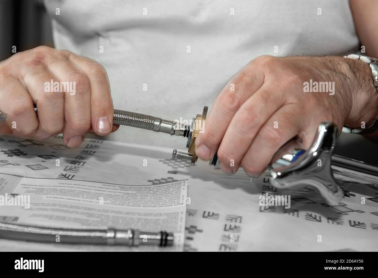 Les mains plomber au travail dans la salle de bains, les réparations de plomberie, l'assemblage et l'installation d'un robinet de bain. Le concept de remplacement du joint en caoutchouc pour Banque D'Images