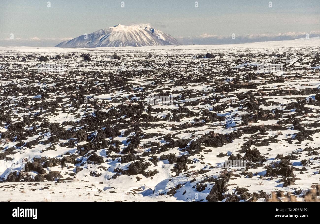 La neige couvre certaines des formations de lave noires qui sont parmi les caractéristiques du monument national Craters of the Moon et de préserver qui s'étend sur la plaine de la rivière Snake dans l'Idaho, aux États-Unis. Ce paysage particulier est le résultat de huit éruptions volcaniques majeures qui ont commencé il y a 15,000 ans et se sont poursuivies jusqu'à il y a seulement 2,000 ans. Les géologues prédisent que la région fera l'expérience d'une autre éruption dans les 100 à 900 prochaines années. Vous pourrez visiter le parc en voiture ou à pied. En arrière-plan se trouve la grande Butte du Sud, un complexe de trois dômes volcaniques qui se sont formés il y a environ 300,000 ans Banque D'Images